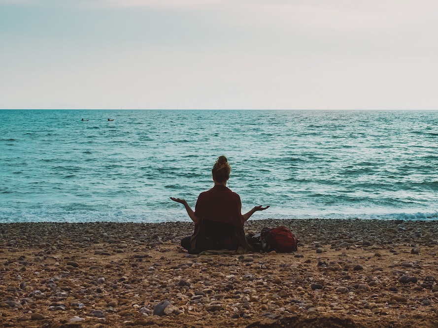 Woman Meditating by the Beach