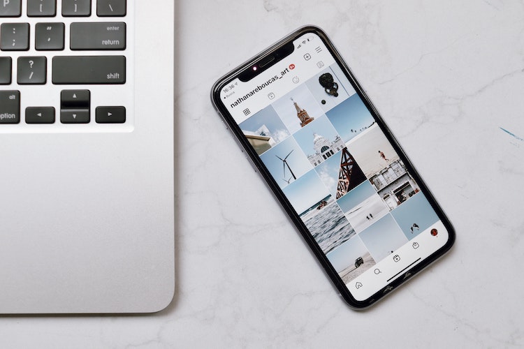 30 Instagram Caption Ideas Banner Image - Image of blue and white phone instagram screen and silver macbook